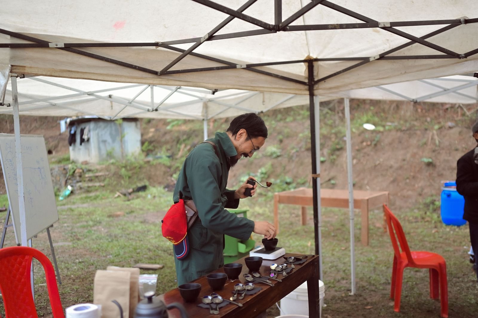 A trainer grinding coffee at a cupping table