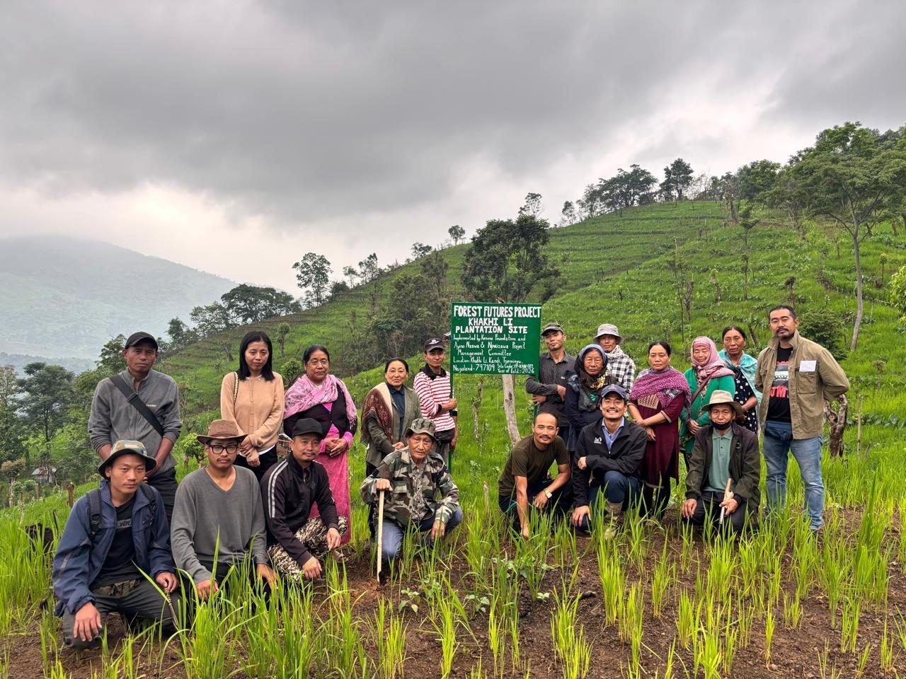 Planting team gathered at a project site sign