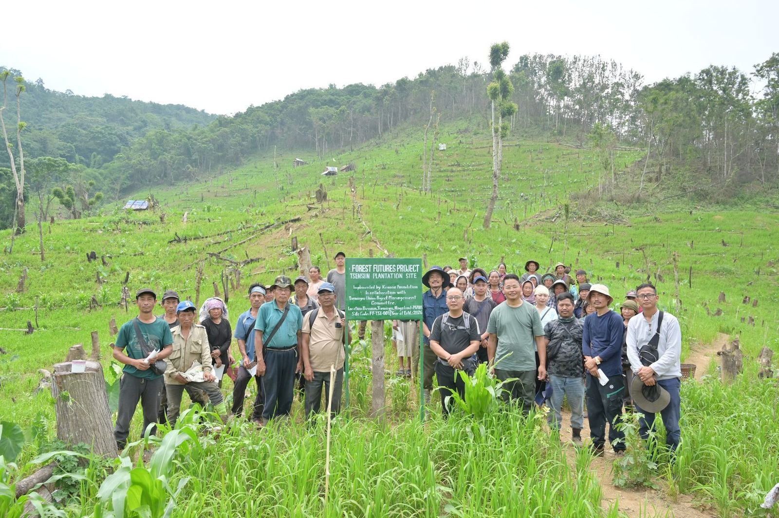 The planting team gathered at the Tsensun site sign
