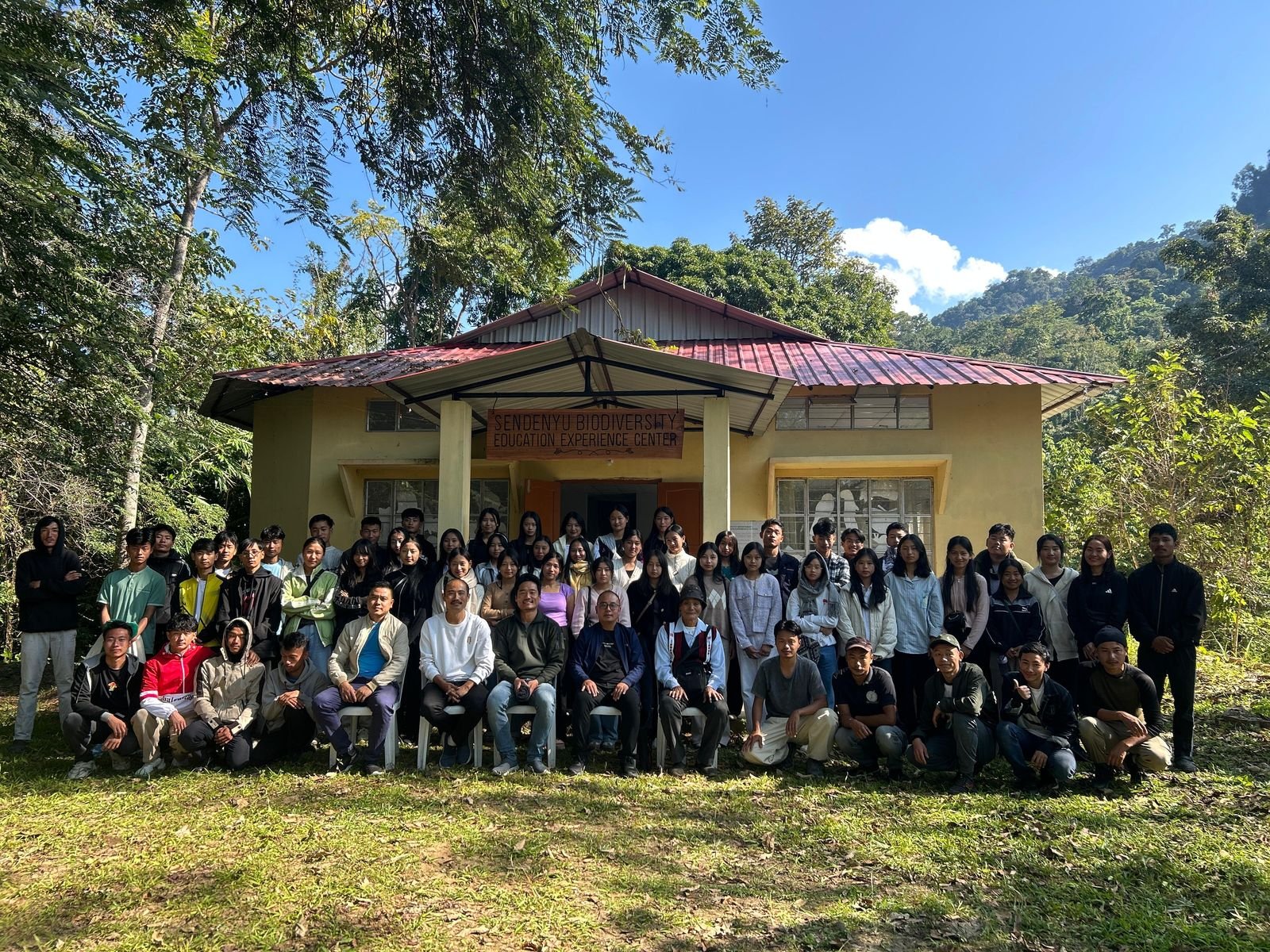 Students, youth leaders, and village elders gathered in front of the Sendenyu Biodiversity Education Experience Centre