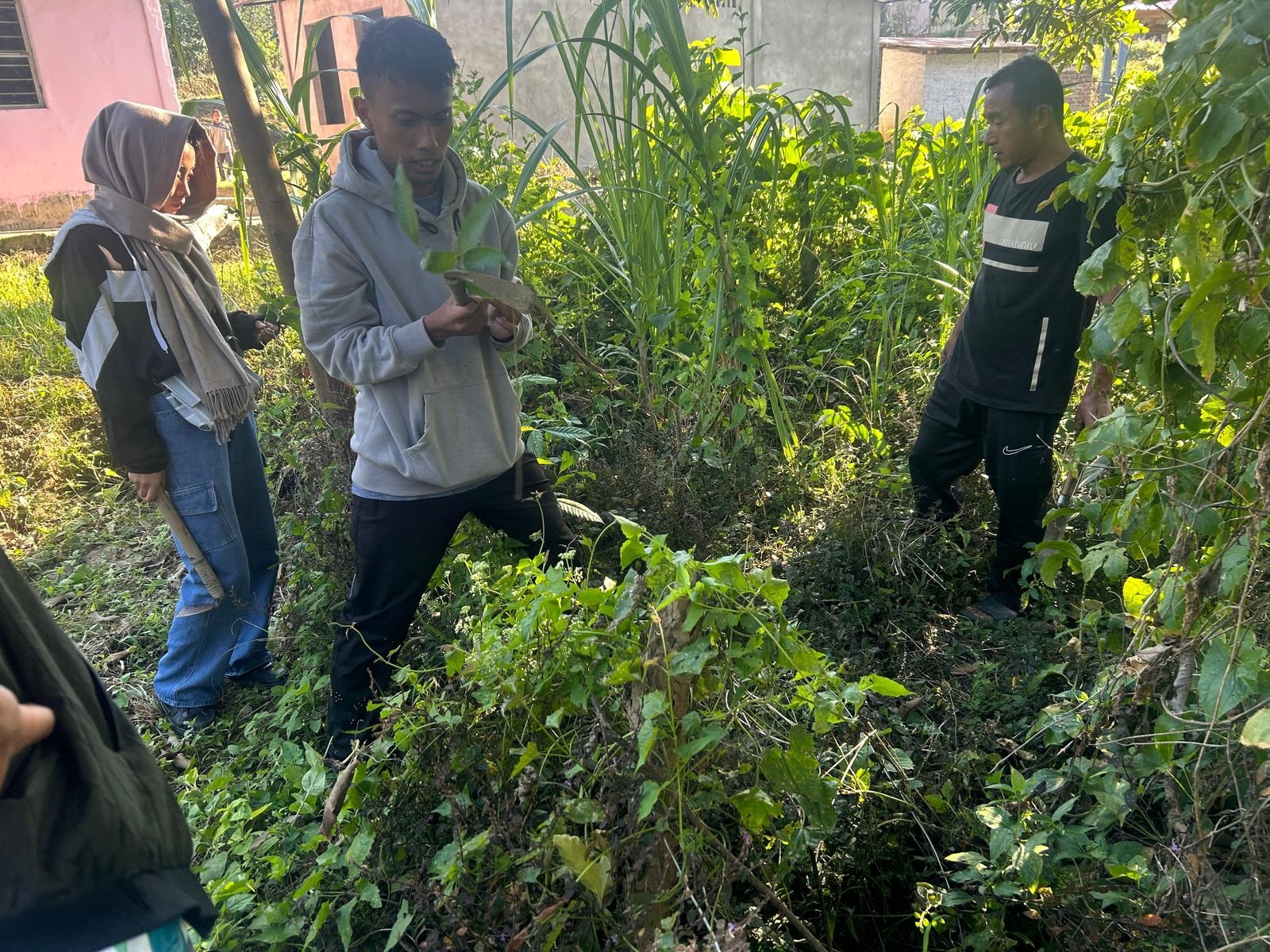 A village knowledge holder showing a seedling to students