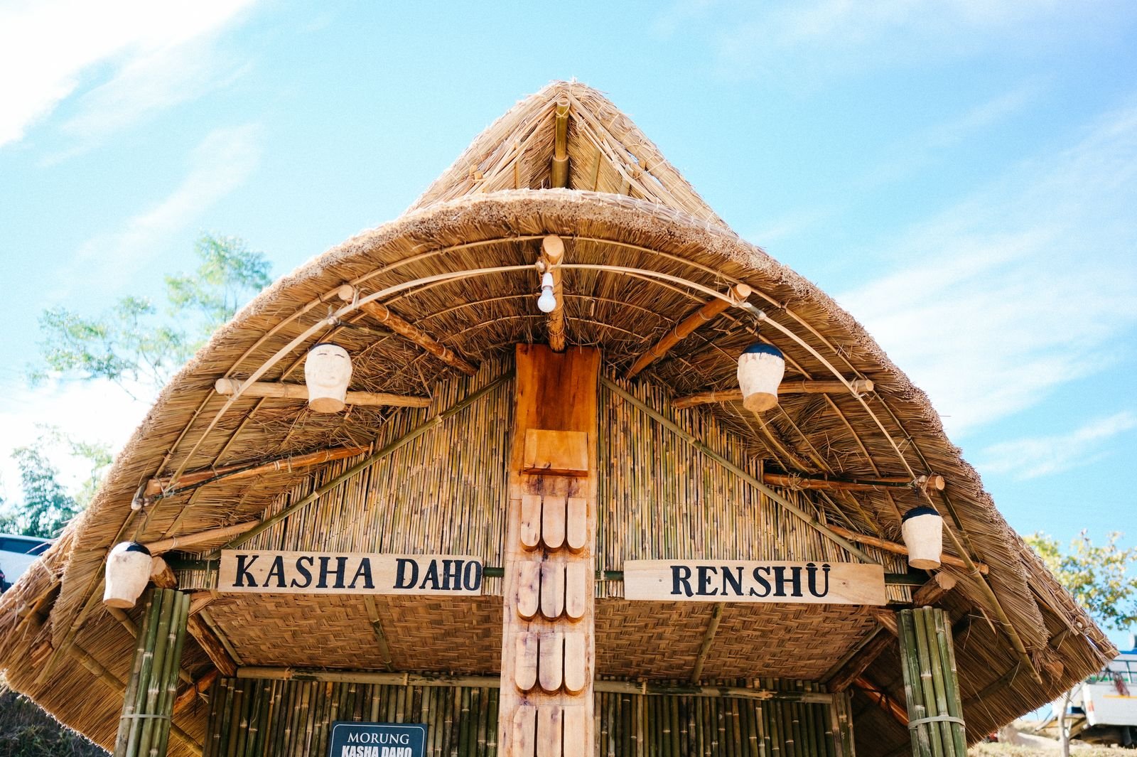 A newly built morung with a thatched roof and carved posts